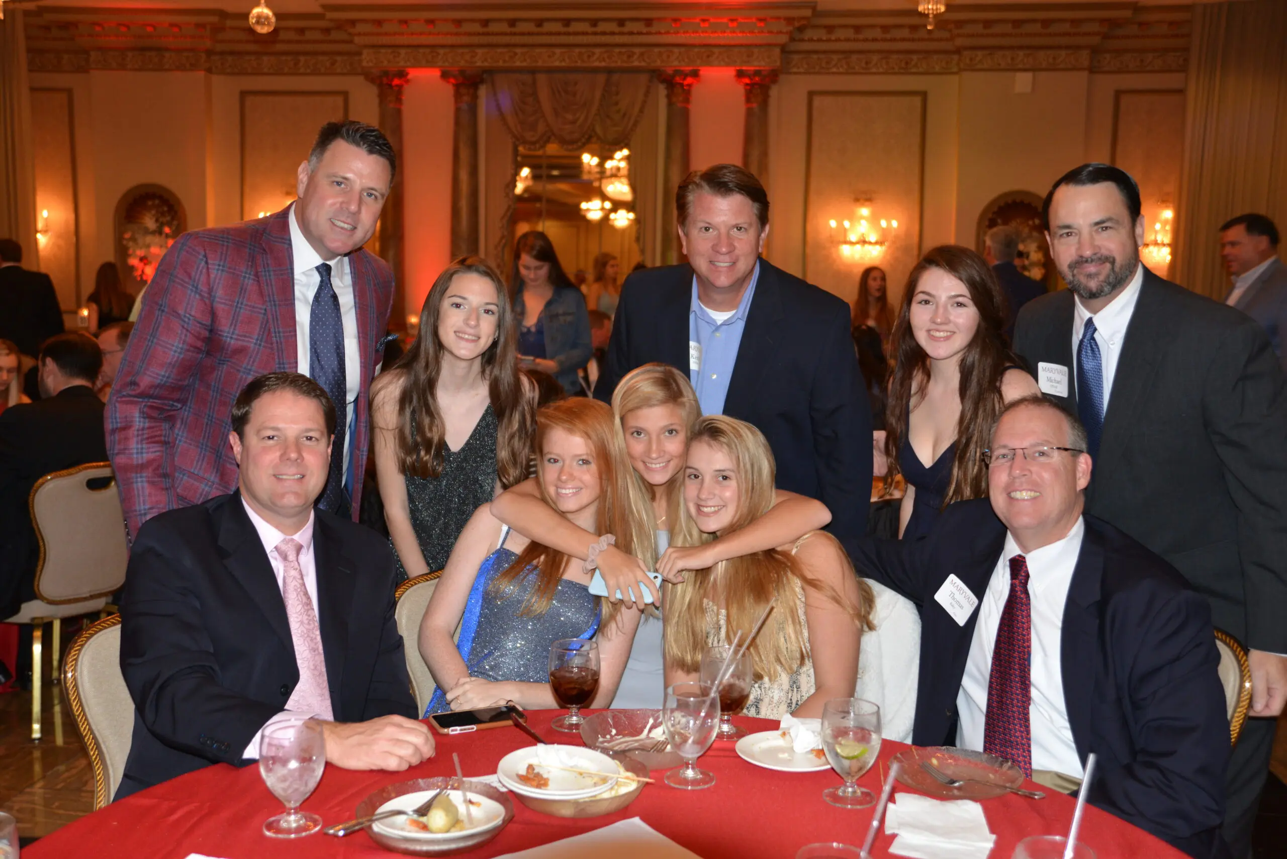 A large group of fathers and daughters gathered around a table