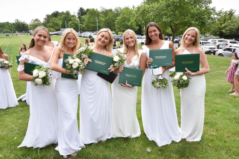 Six young girls holding their high school diplomas